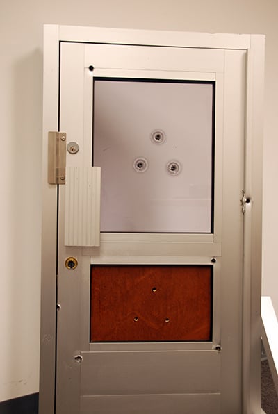 A visual that shows the effect of bullets on a security front door from Total Security Solutions